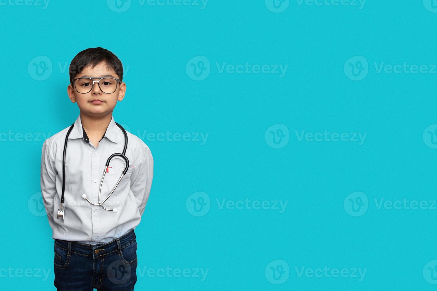 lächelnder kleiner Junge mit Stethoskop und Brille isolierter Hintergrund mit Kopienraum foto
