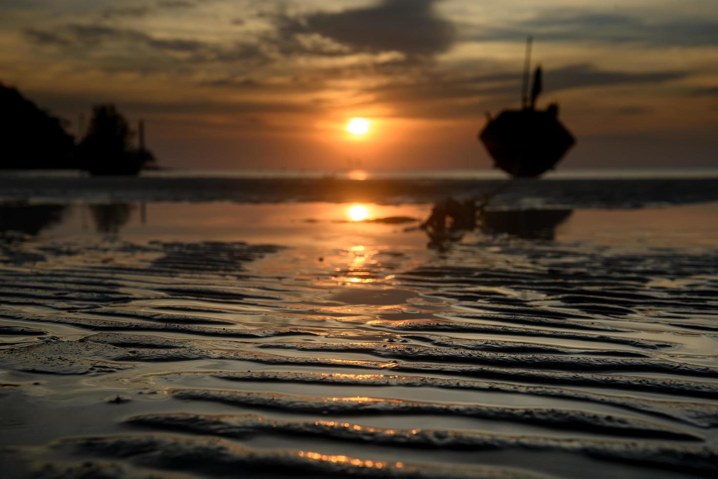 Strandsandlinie mit Sonnenuntergang. foto