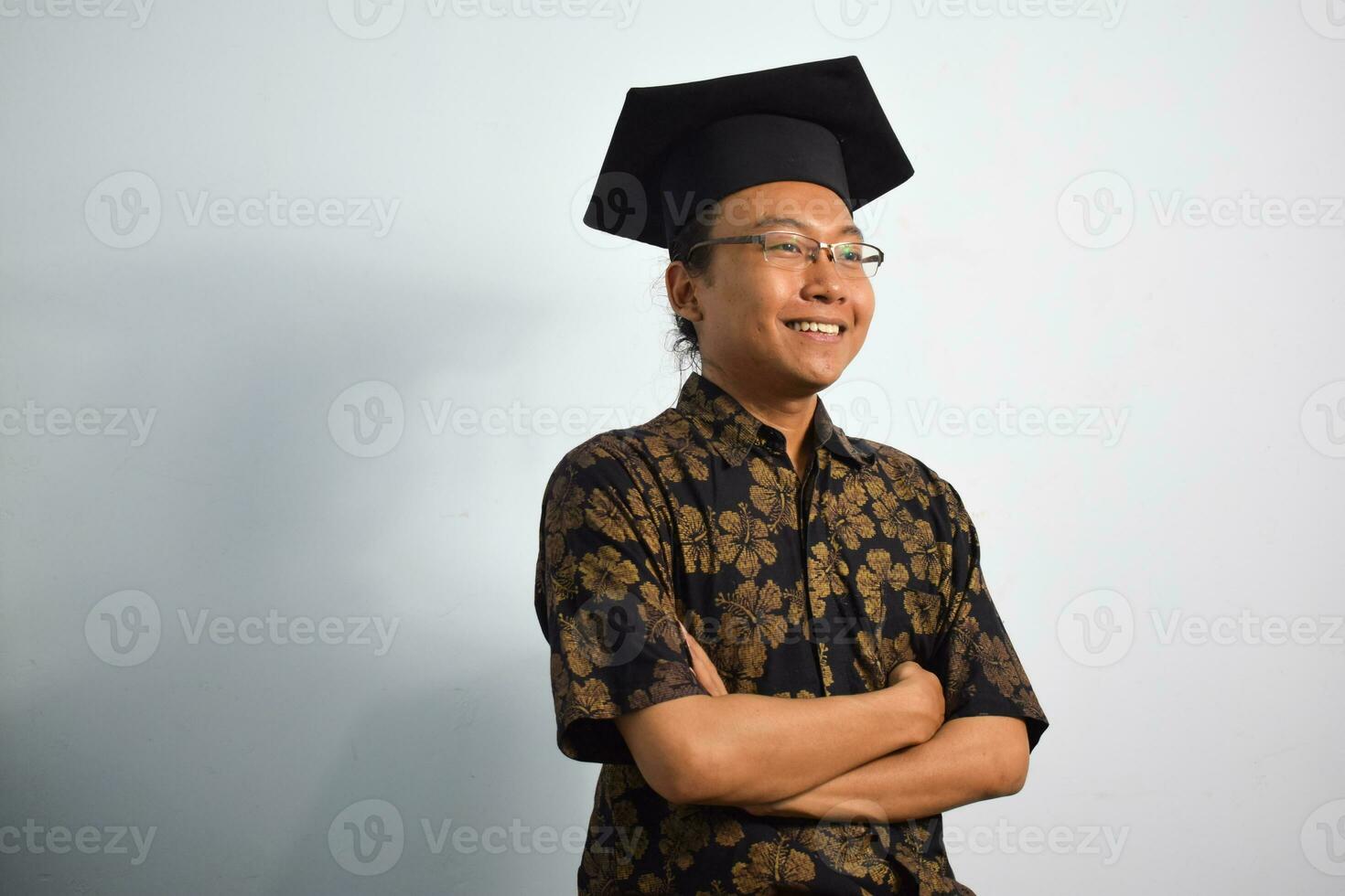 ausdrucksvoll von Erwachsene Indonesien männlich tragen Batik, Toga Tasse oder Abschluss Hut und Brille isoliert auf Weiß Hintergrund, Ausdrücke von Porträt Abschluss foto