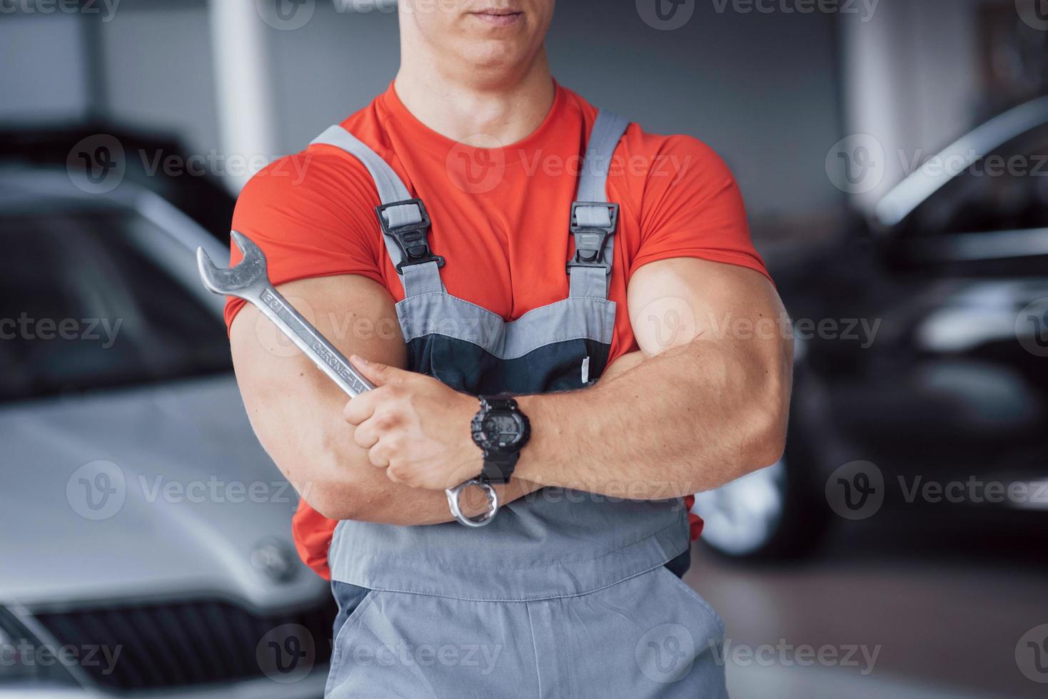 Hände des Automechanikers mit Schraubenschlüssel in der Garage foto