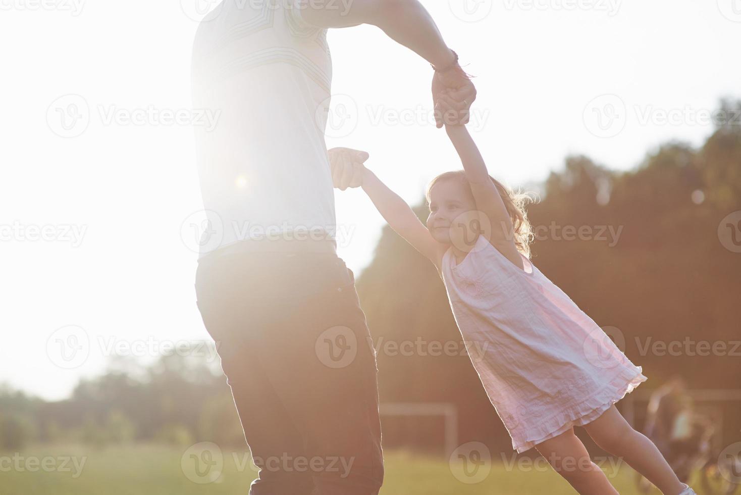 Vater und Tochter spielen zusammen draußen foto