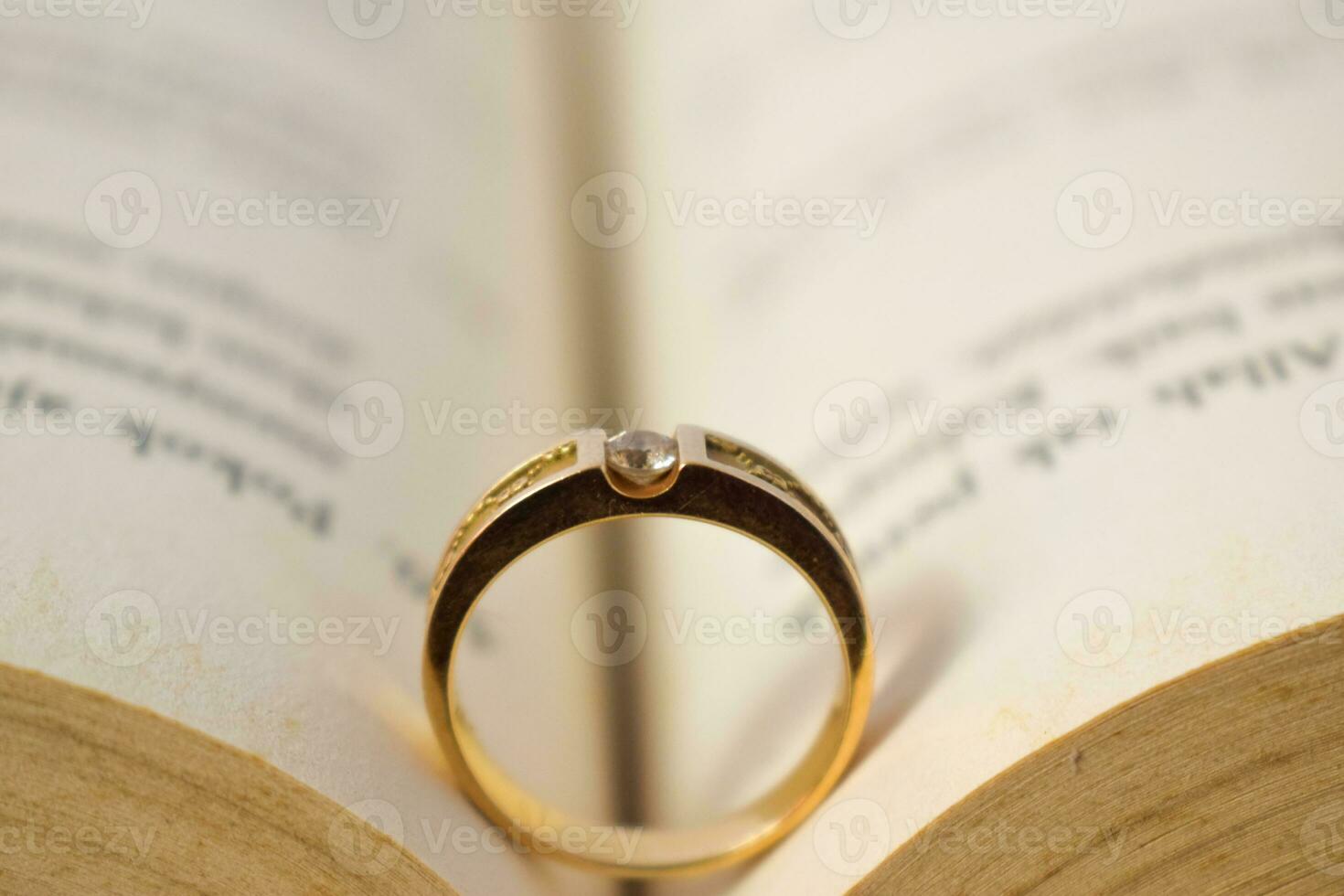 schließen oben golden Ring mit Diamant zwischen Buch geöffnet foto