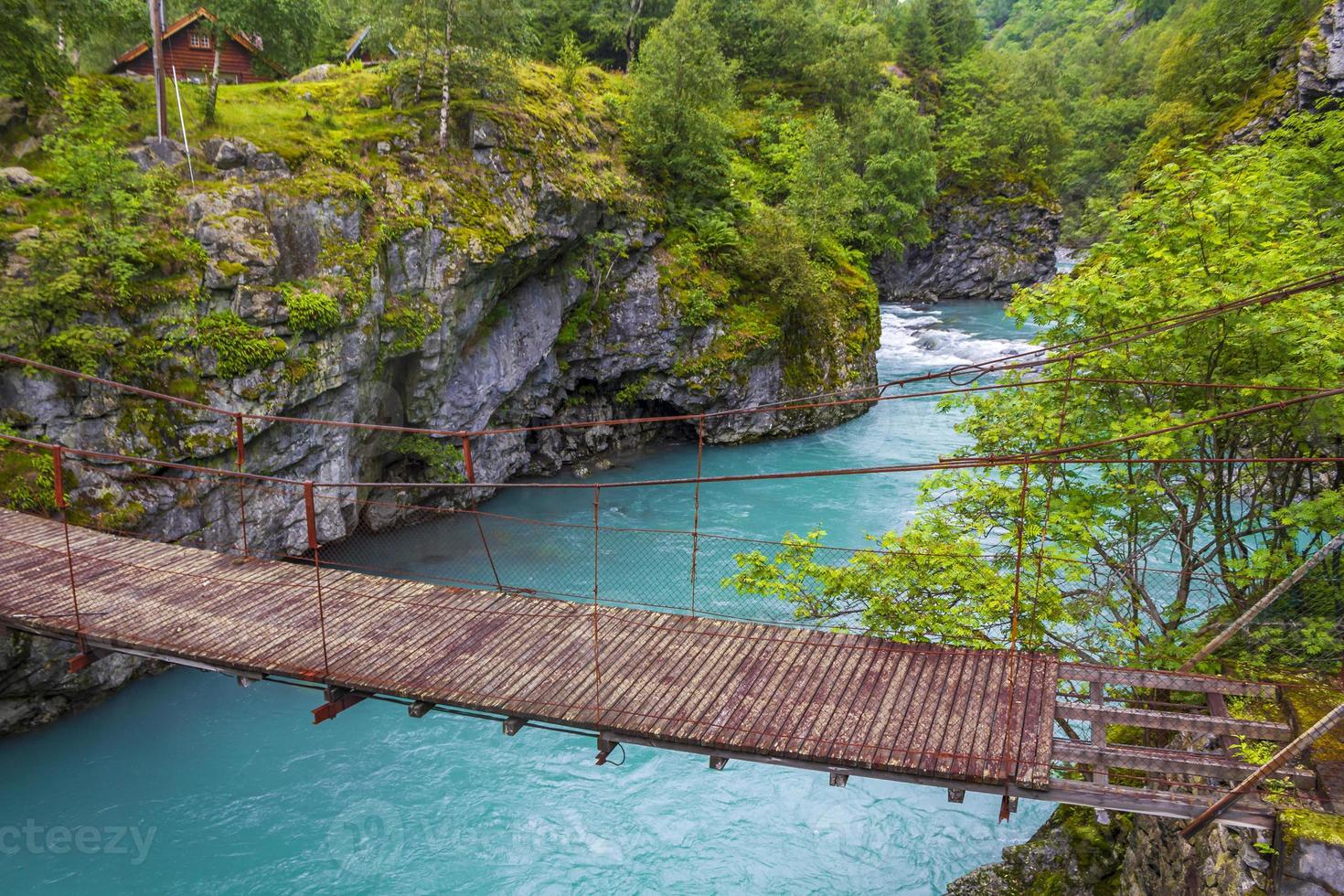 schöne holzbrücke über türkisfarbenen fluss utla utladalen norwegen landschaften. foto