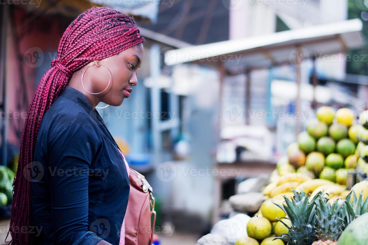 schöne junge Frau auf dem Obstmarkt der Straße foto