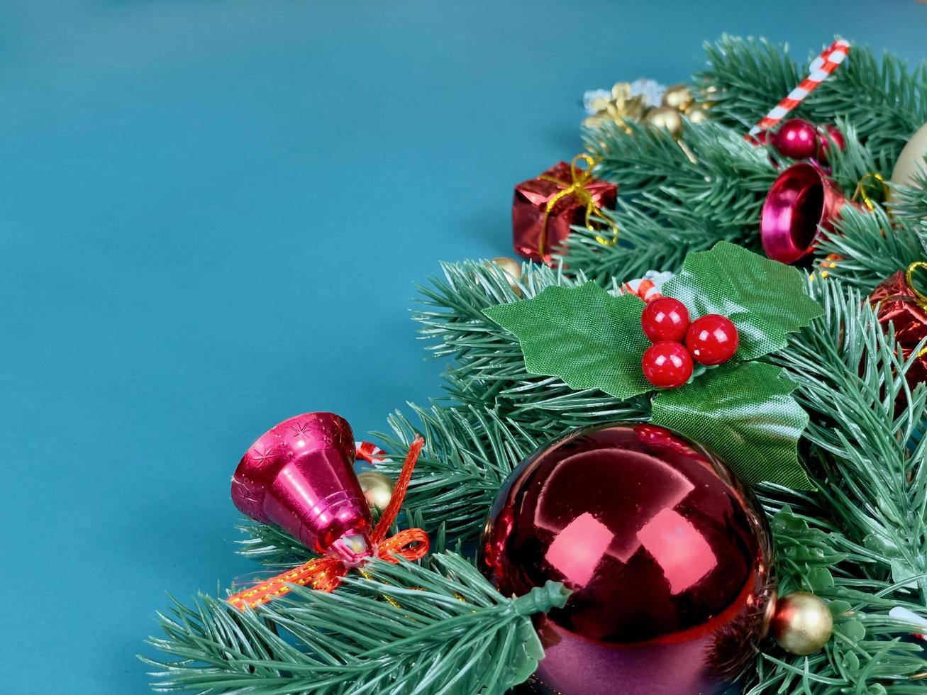 Weihnachtsschmuck, Kiefernblätter, goldene Kugeln, Schneeflocken, rote Beeren und goldene Beeren auf blauem Hintergrund foto