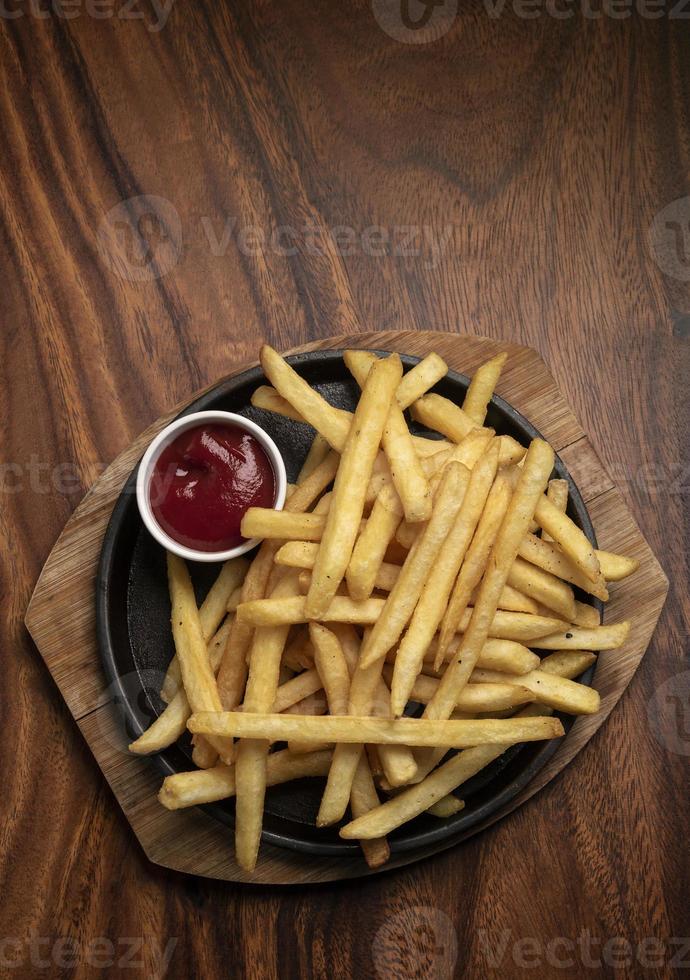 Portion Pommes Frites Kartoffelsnack auf Holztisch Hintergrund foto