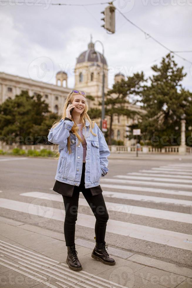 junge Frau mit Handy auf der Straße von Wien, Österreich foto