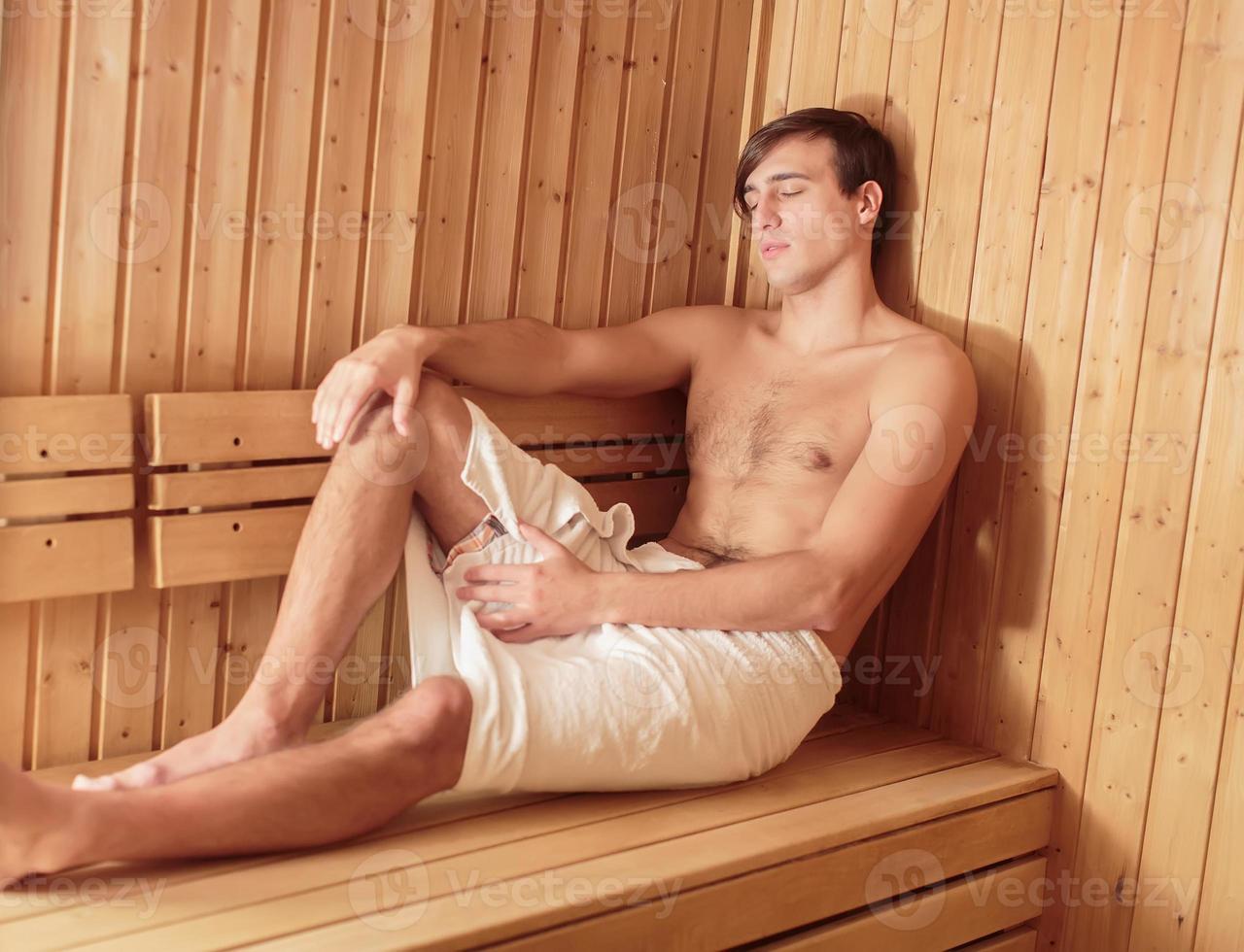 junger Mann entspannt sich in der Sauna foto