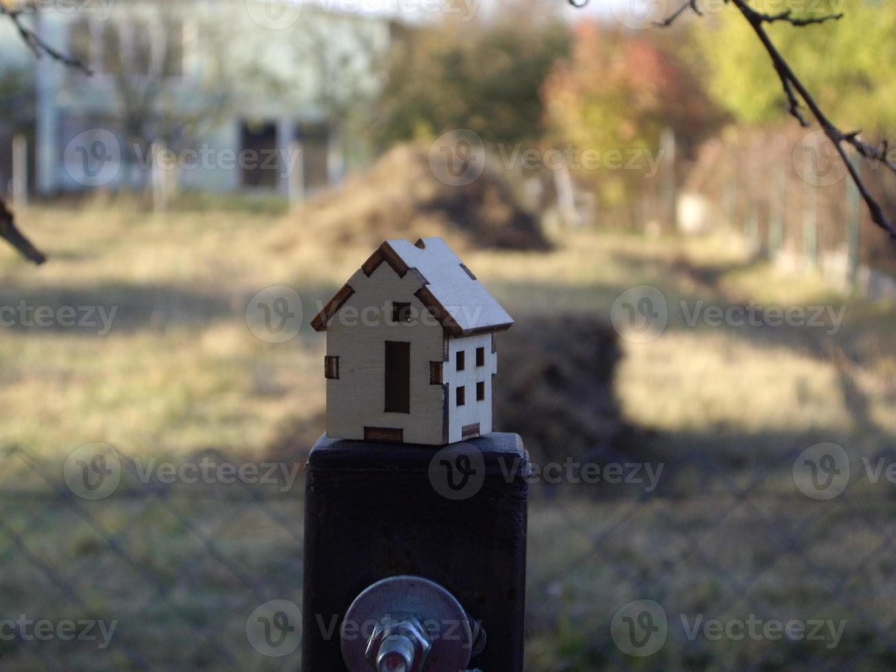 Modell eines kleinen Holzhauses im Hintergrund des Dorfes foto