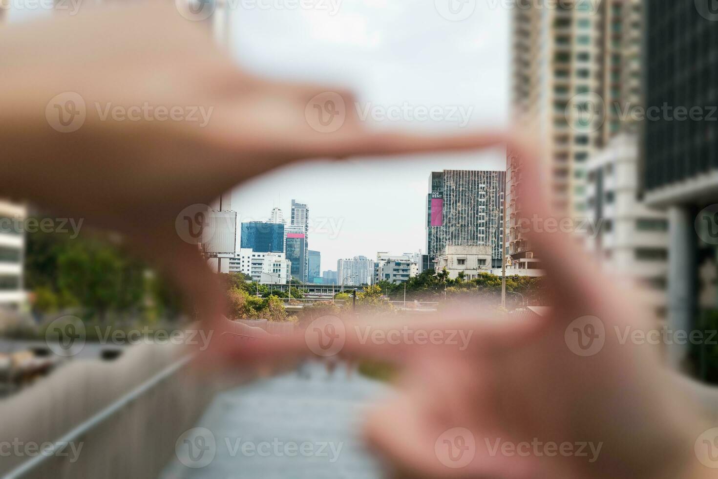 Geste von Hand schafft ein Rahmen suchen durch das Fokus von das groß Geschäft Kreis Hauptstadt Stadt klar Hintergrund Bild. Konzept von Geschäft Rahmen klar Tore und Vision. foto