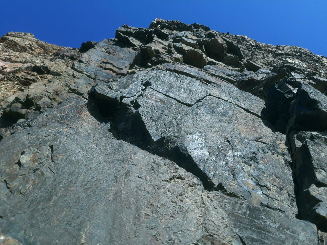 schwarz Stein Hintergrund. lange schwarz Stein Textur und strukturiert. schmutzig schwarz Stein Mauer. Felsen Textur mit Risse. Stein Fliese Fußboden Textur. alt Mauer Textur abstrakt natürlich Hintergrund. foto