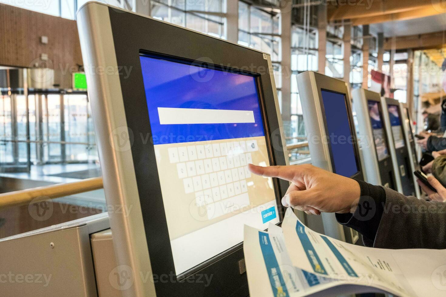 Tourist Hand berühren Anzeige beim Selbstbedienung Transfer Maschine, Kauf Flugzeug oder Zug Tickets beim automatisch Gerät beim Flughafen foto