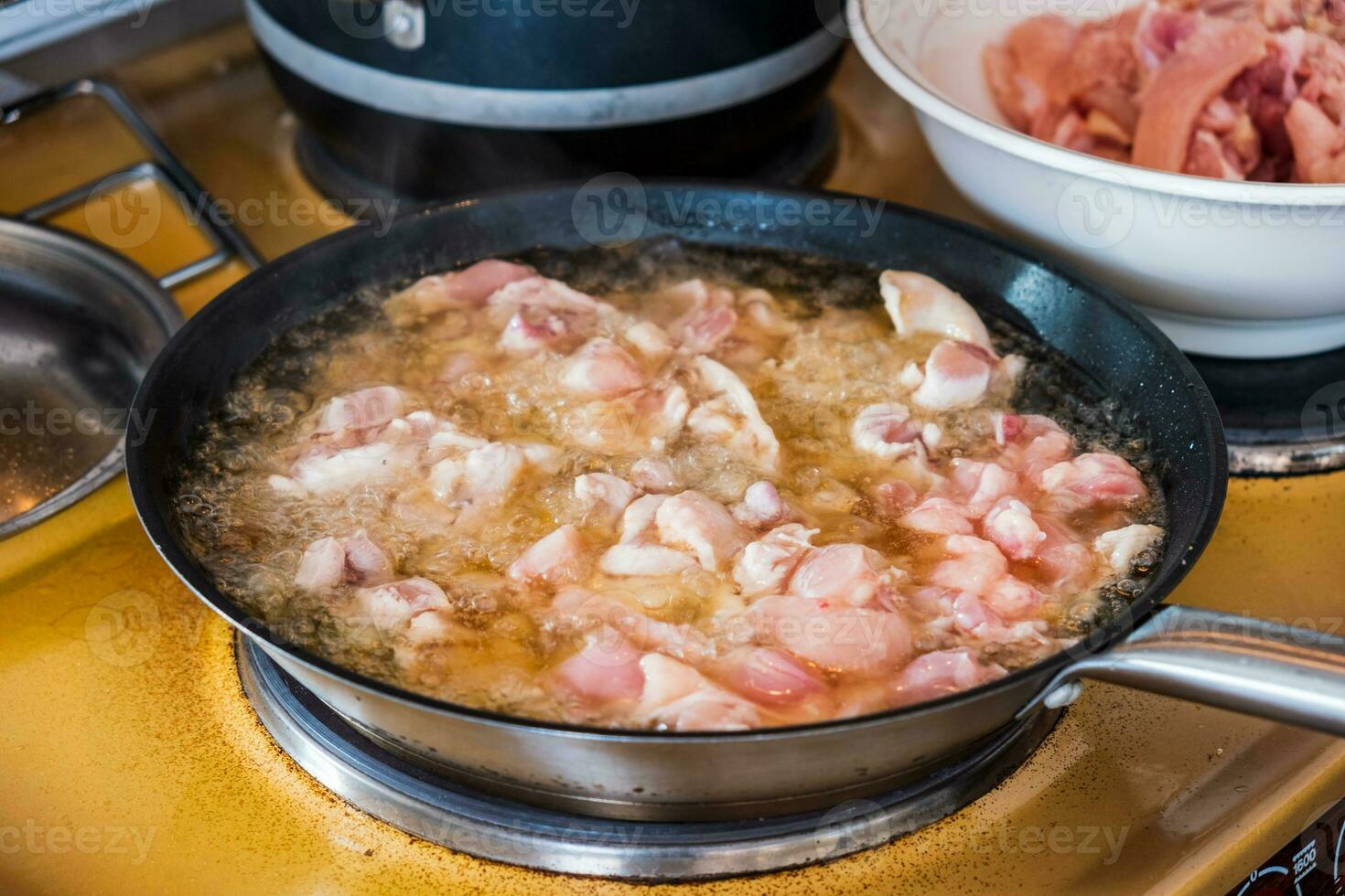 Koch Kochen Hähnchen braten Kochen im Öl mit Bratpfanne foto