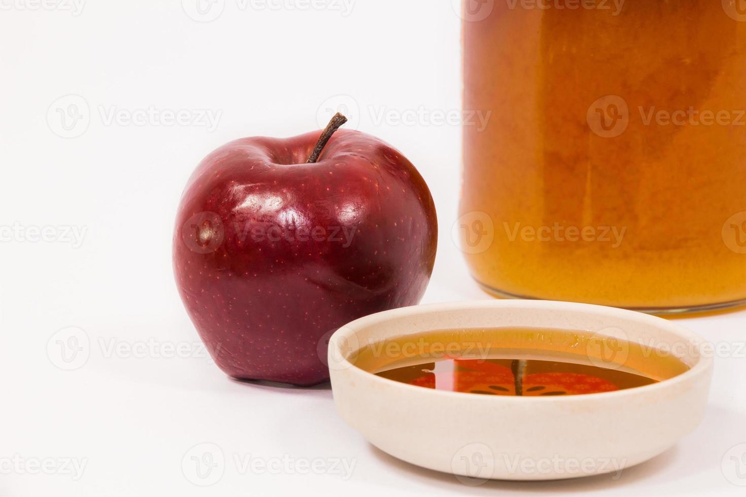 roter Apfel und Glas Honig Schüssel Honig isoliert auf weißem Hintergrund foto