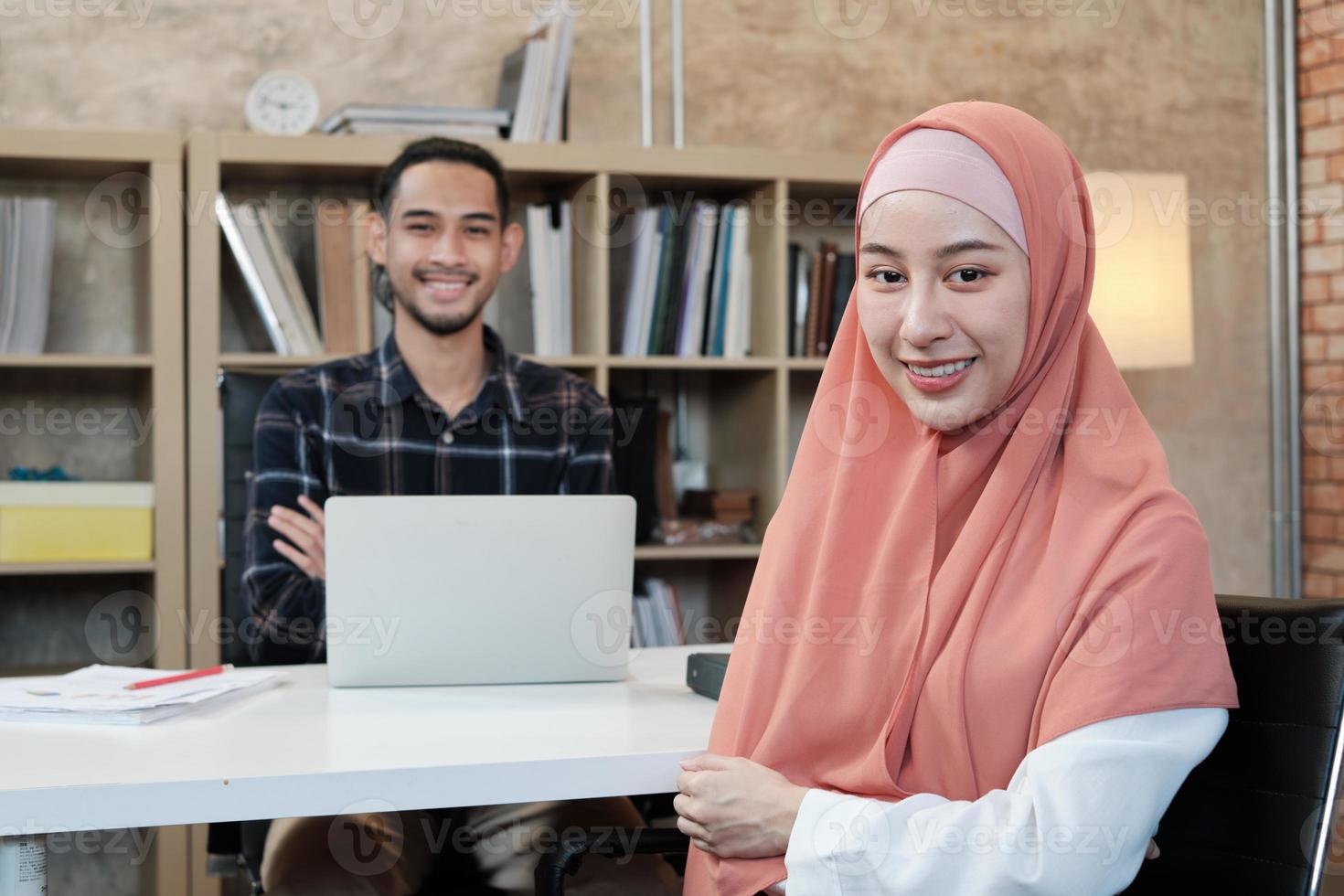 Porträt des Unternehmers der Unternehmensgründung, junger männlicher und schöner weiblicher Besitzer, zwei Partner islamischer Menschen, Blick in die Kamera, verschränkter Arm und glückliches Lächeln in einem kleinen E-Commerce-Arbeitsplatzbüro. foto