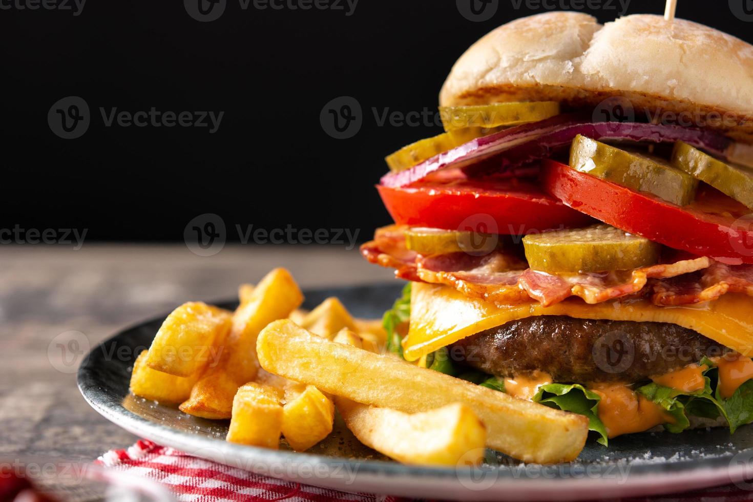 Rindfleischburger mit Käse, Speck und Pommes frites foto