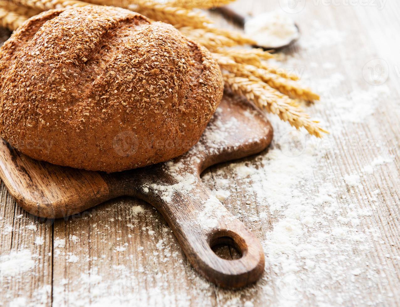 Brot mit Weizenähren und Mehl foto