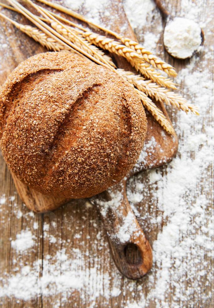 Brot mit Weizenähren und Mehl foto