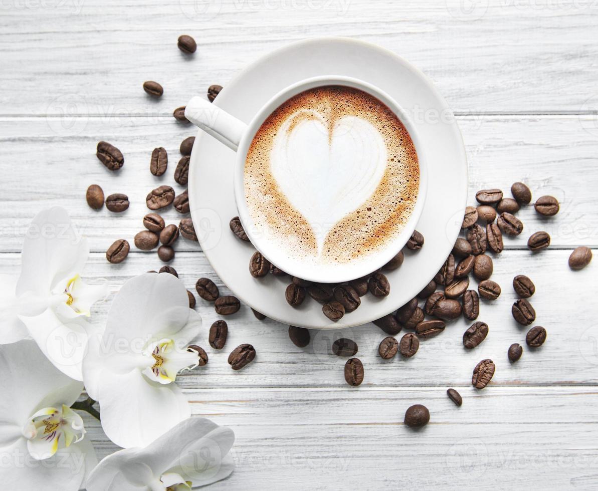 eine Tasse Kaffee mit Herzmuster auf einem Tisch foto