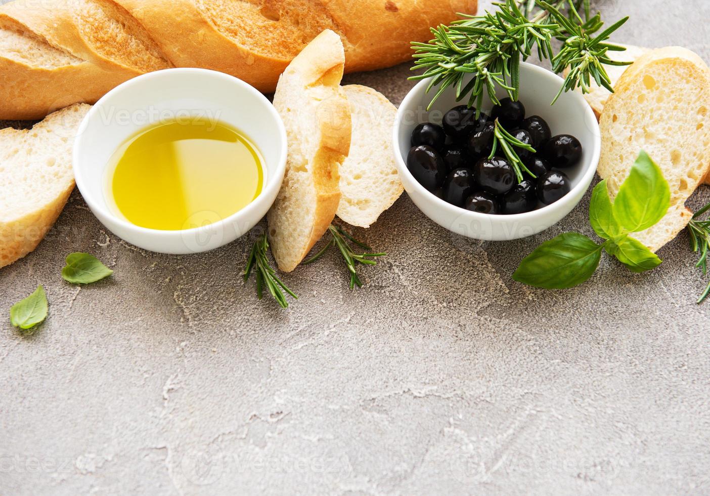 in Scheiben geschnittenes frisches knuspriges Baguette mit Oliven und Gewürzen foto