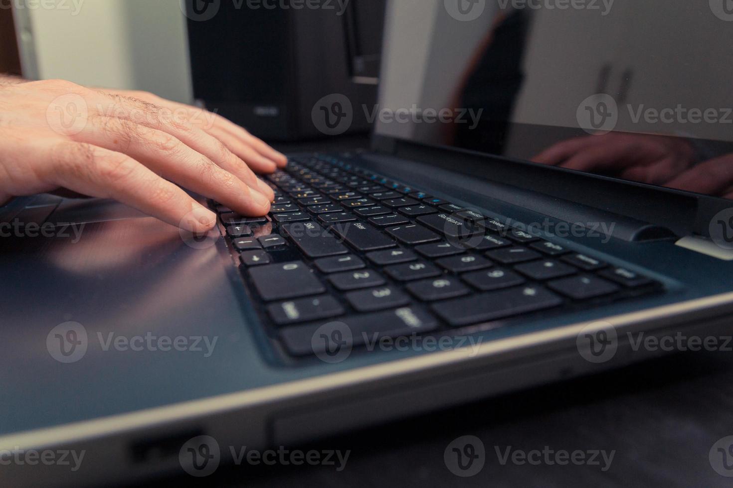 Mann tippt auf einer Tastatur mit Buchstaben in Hebräisch und Englisch foto