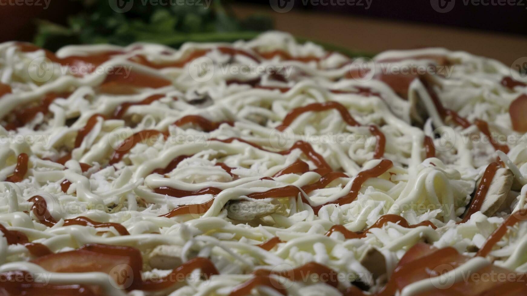 Hinzufügen Soße. Italienisch Pizza Vorbereitung. rahmen. Käse Sein Verbreitung auf Tomate Soße auf Pizza Base. Nahansicht Hand von Koch Bäcker im Weiß Uniform Herstellung Pizza beim Küche foto
