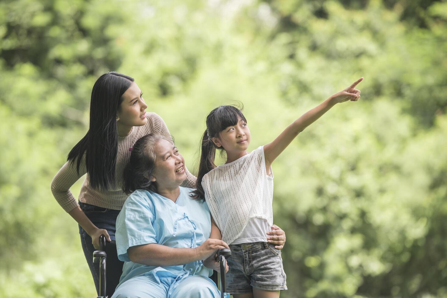 glückliche Großmutter im Rollstuhl mit ihrer Tochter und ihrem Enkel in einem Park, glückliches Leben glückliche Zeit. foto