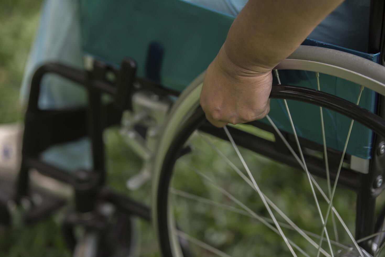 Nahaufnahme einer einsamen älteren Frau, die im Garten im Krankenhaus im Rollstuhl sitzt foto