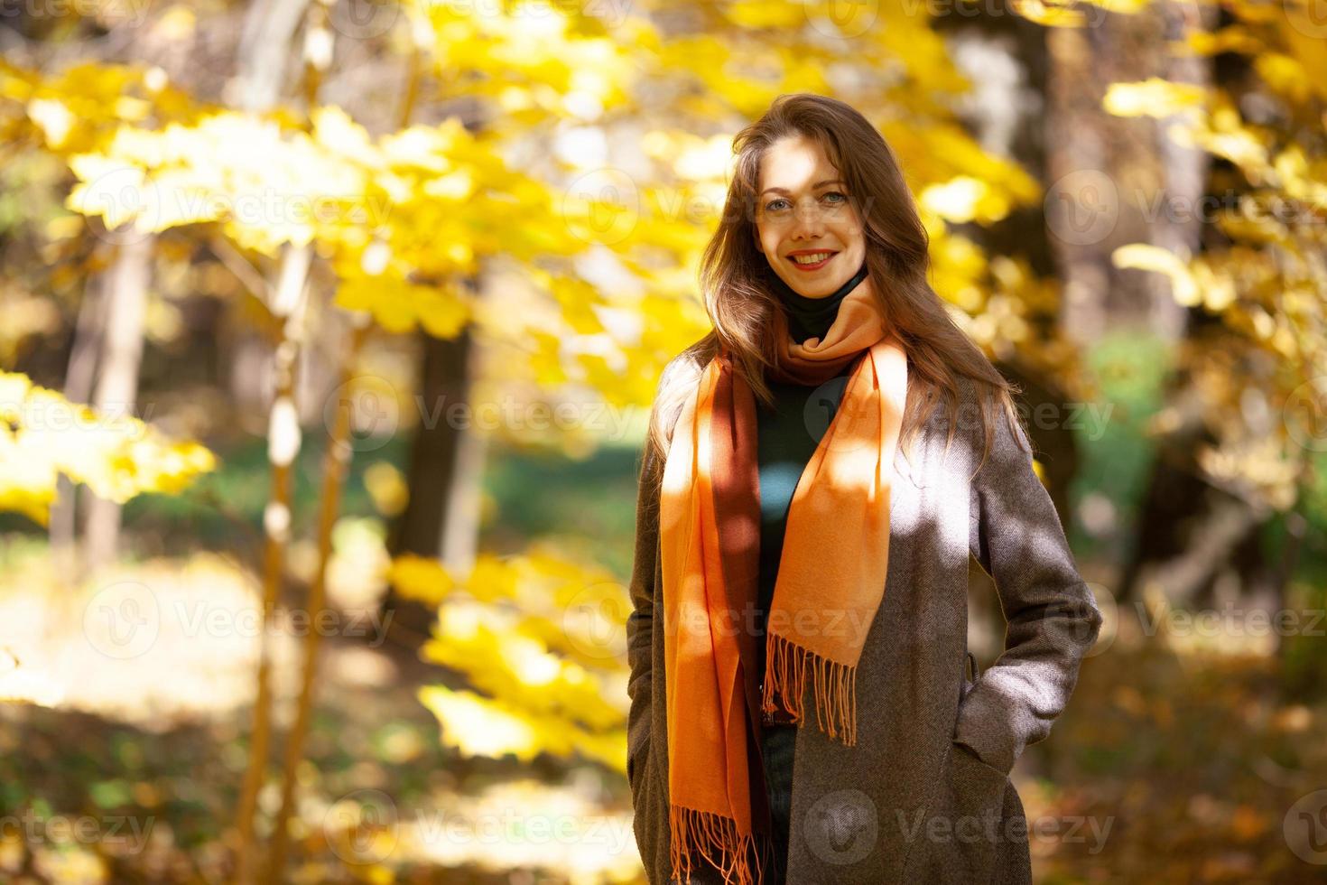 junge Frau, die im Herbstwald spaziert foto