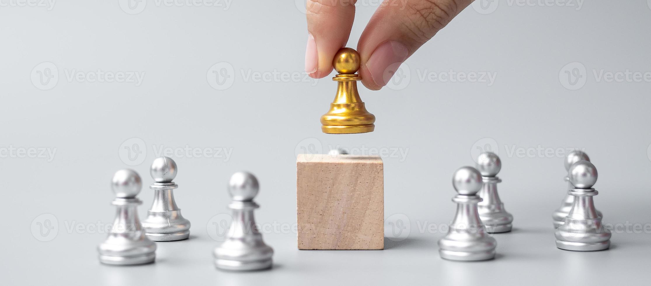 Hand, die goldene Schachfiguren oder Führergeschäftsmann mit silbernen Männern hält. Sieg, Führung, Geschäftserfolg, Team, Recruiting und Teamwork-Konzept foto