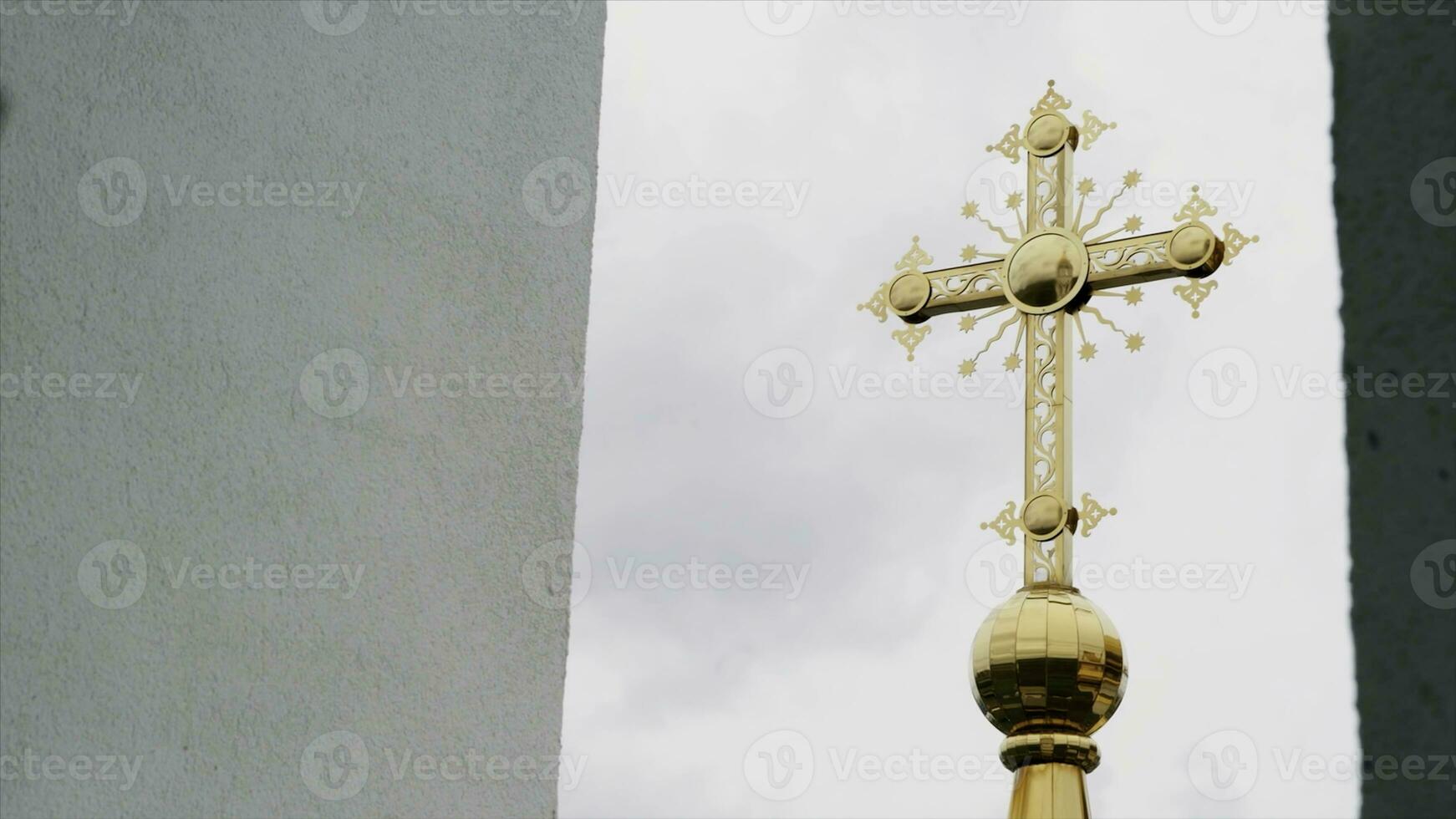 Religion und Vertrauen Konzept, Unterseite Aussicht von ein golden Kreuz von das Kirche. Video. groß golden Kreuz auf wolkig Himmel Hintergrund. foto