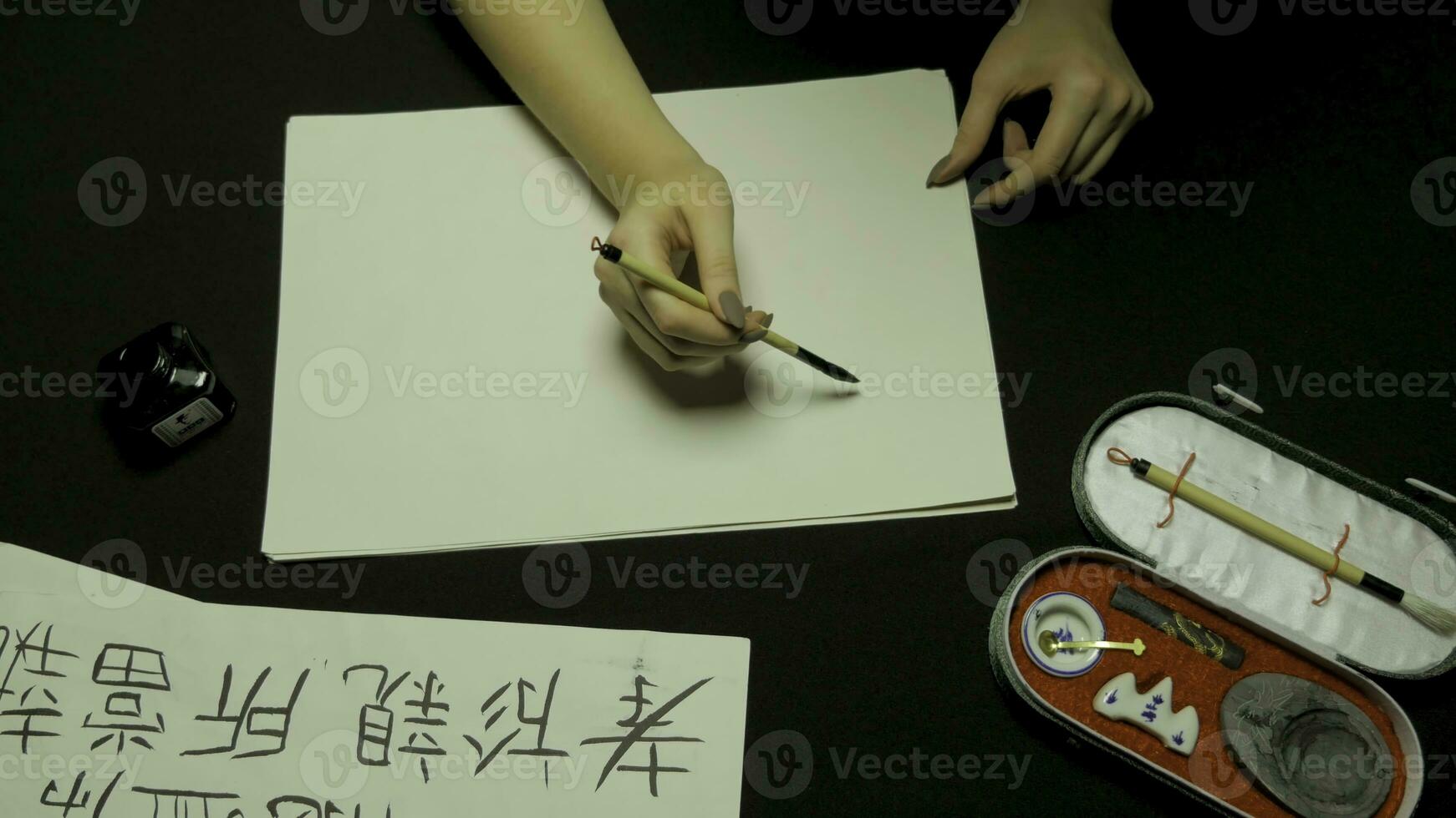 Frau Hand Schreiben Chinesisch Kalligraphie. weiblich Hand halten ein Schreiben Bürste Chinesisch Zeichen foto