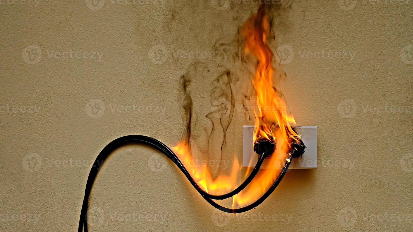 on fire elektrische kabel steckdose auf dem betonwand hintergrund foto