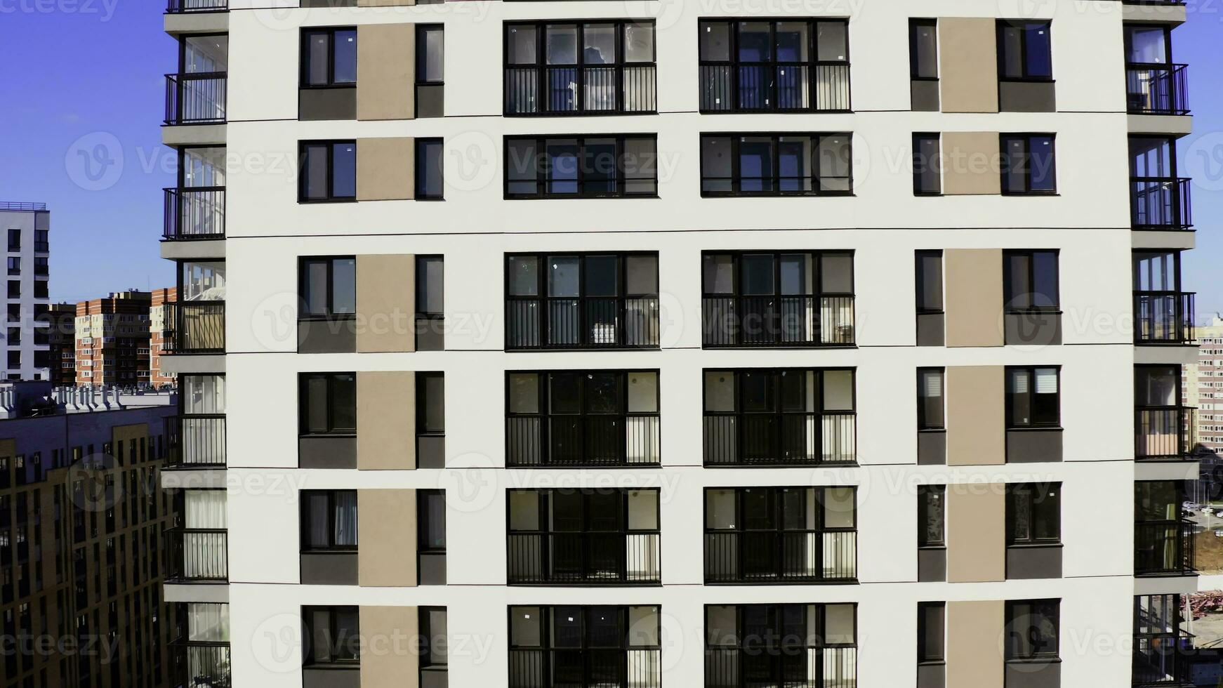 fliegend schließen zu das Neu multi Stockwerk Gebäude mit Balkone und groß Fenster. Lager Filmaufnahme. Gebäude von das Stadt Schlafen Bereich. foto