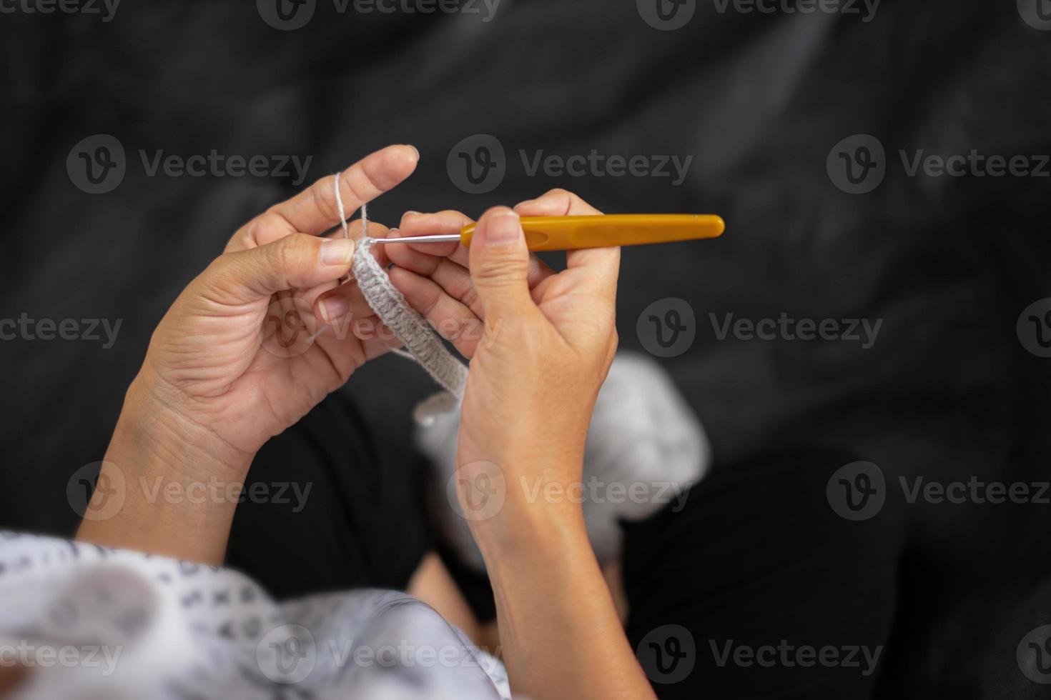 Nahaufnahme von Frauenhänden stricken, weiblicher Handstrickhaken, Frauen strickt häkeln foto