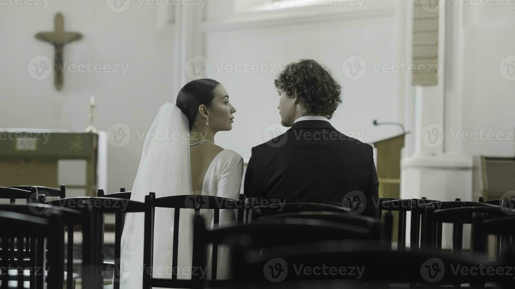 Braut und Bräutigam beim das Hochzeit Zeremonie im modern Kirche. Aktion. Frau und Mann Sitzung zusammen unter leeren Sitze. foto