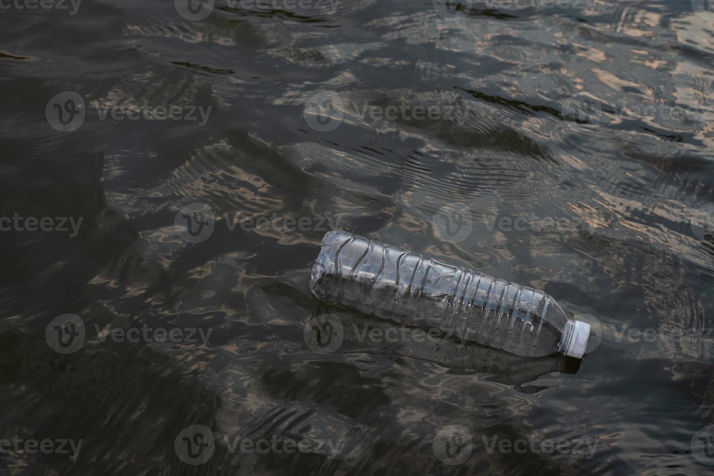 gebrauchte Plastikmüllflasche, die in einem Kanal auf dem Wasser schwimmt, umweltfreundliches Konzept für Umwelt- und Umweltverschmutzung foto