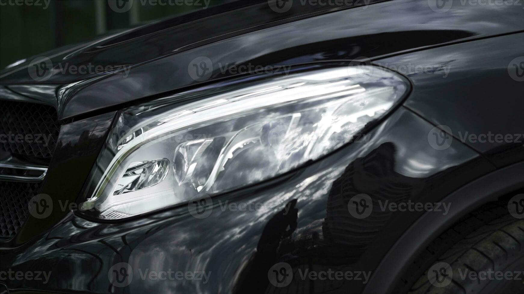 schließen oben Detail zum einer von das LED Scheinwerfer von ein modern schwarz Wagen. Aktie. Außen Detail, Scheinwerfer von ein prestigeträchtig Fahrzeug, Luxus Konzept. foto