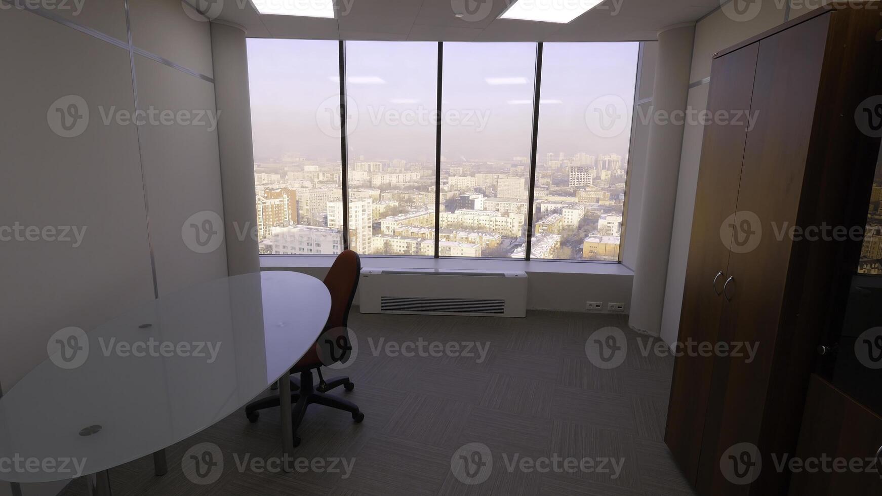 Aussicht von Zimmer von Panorama- Fenster auf Stadt Landschaft. klein gemütlich Zimmer mit Tisch, Stuhl und Kleiderschrank mit Panorama- Fenster. Innere Räume zum Geschäft Reisen von Arbeitskräfte foto