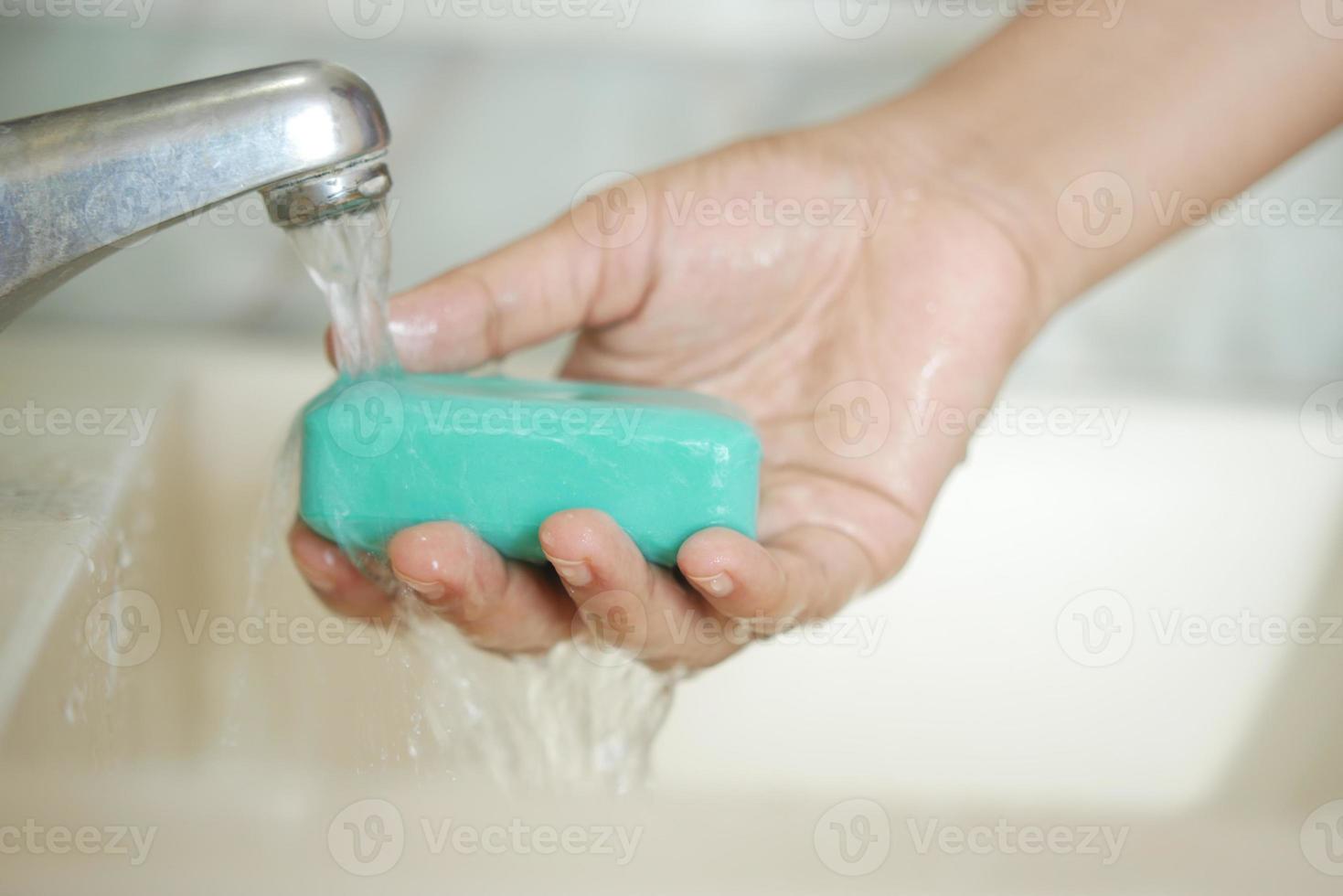 Frauen waschen sich die Hände mit warmem Wasser der Seife foto
