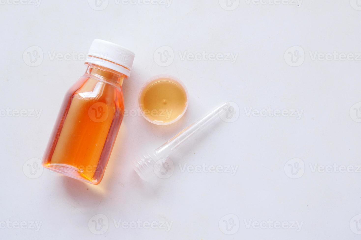 Flasche mit flüssiger Medizin auf Weiß, foto