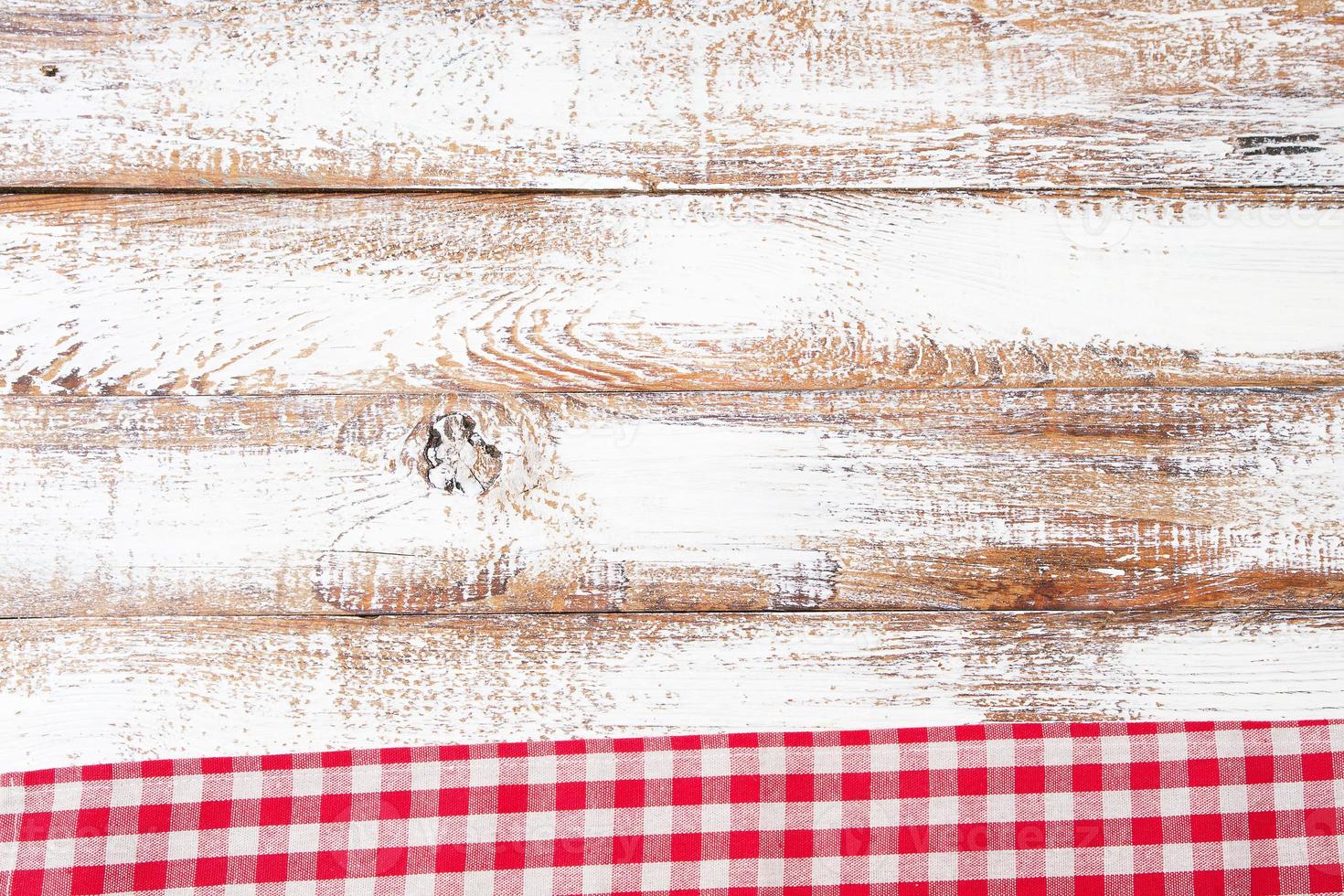 rot karierte Tischdecke auf altem Holztisch, Urlaubskonzept foto