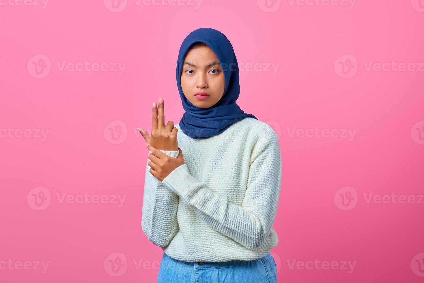 Porträt einer jungen asiatischen Frau, die eine symbolische Waffe mit Handgeste hält foto
