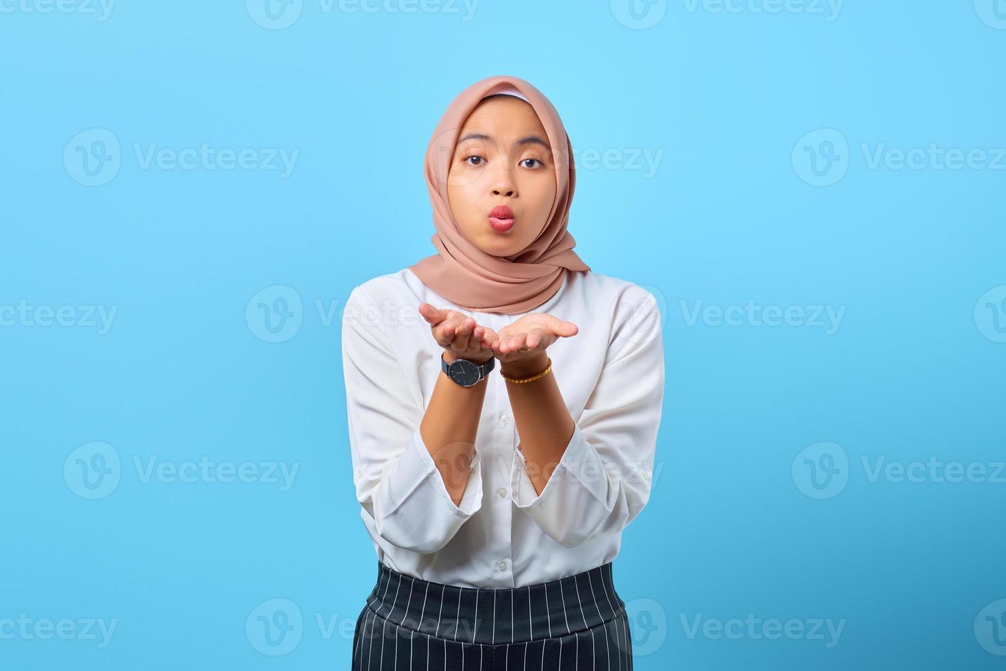 Porträt einer charmanten jungen asiatischen Frau, die Handflächen hält, senden Luftkuss an Freund foto