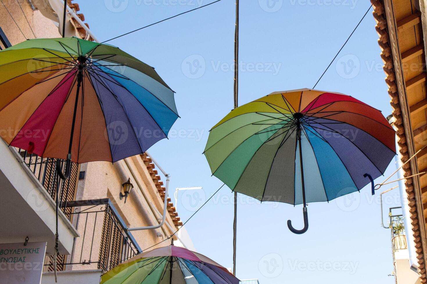 bunt Regenschirme hängend im das Luft auf das Straße im Ägina, Griechenland foto