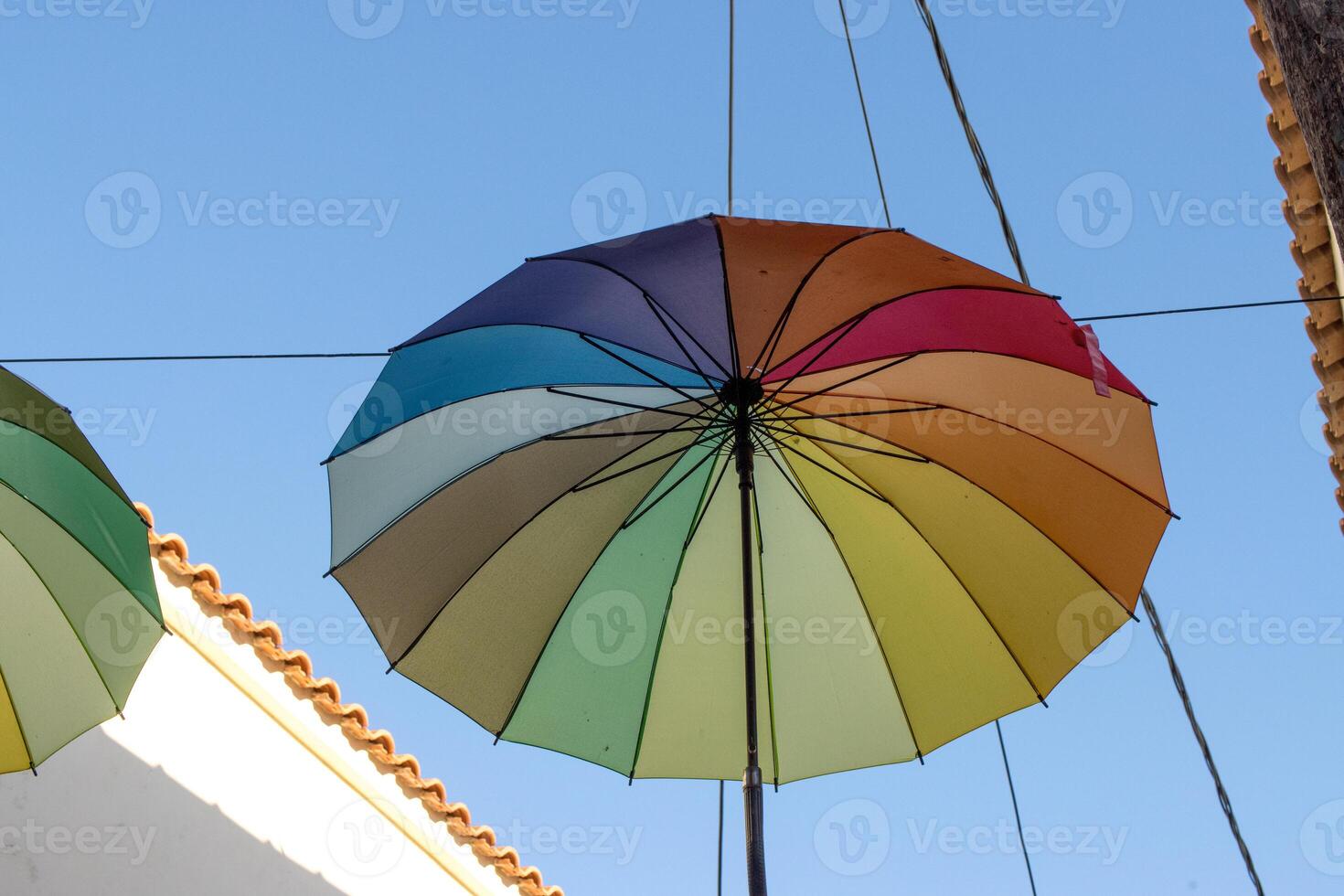 bunt Regenschirme hängend im das Luft auf das Straße im Ägina, Griechenland foto