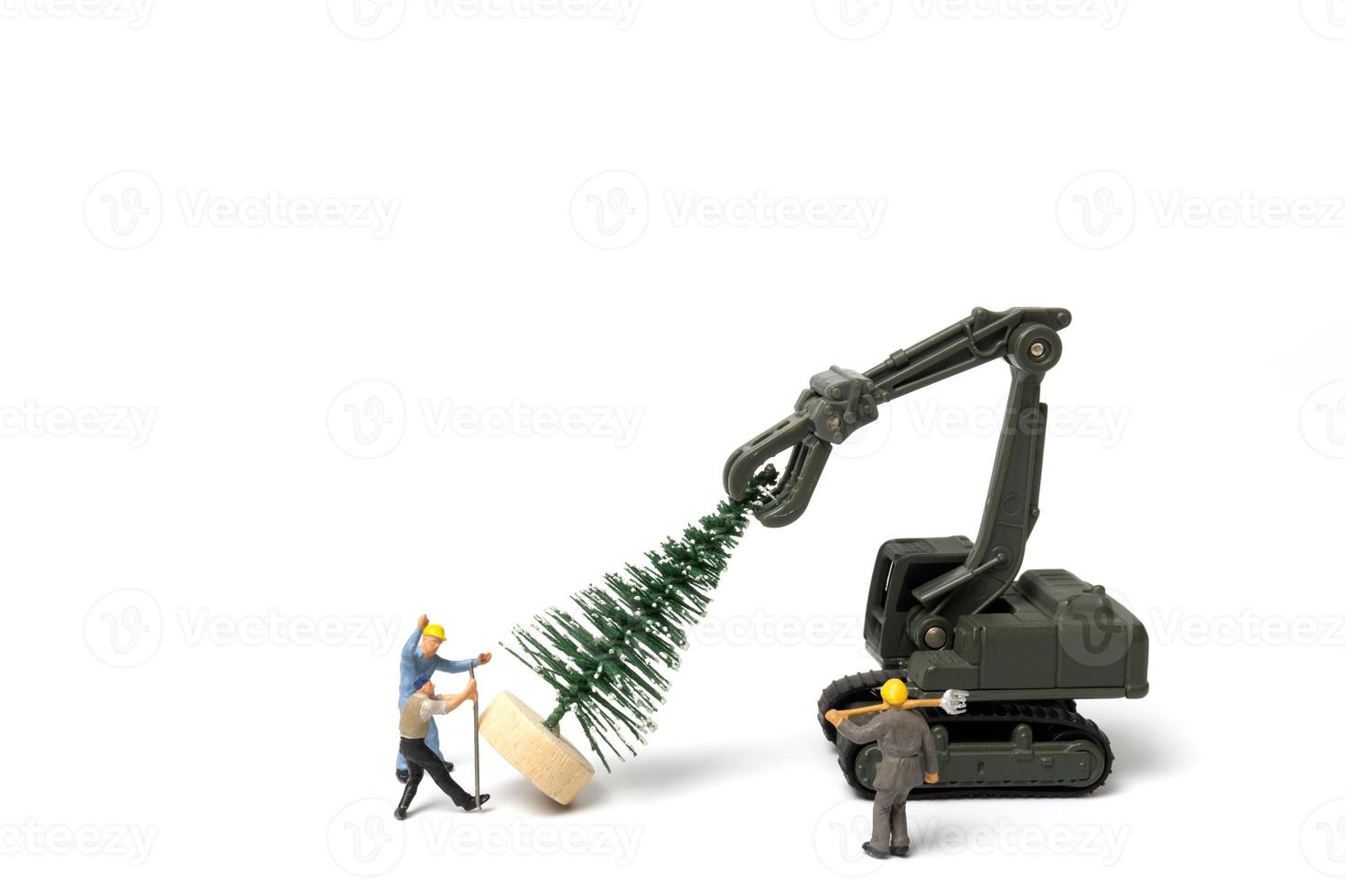 Miniaturleute, Arbeiter, die Weihnachtsbaum auf weißem Hintergrund vorbereiten foto