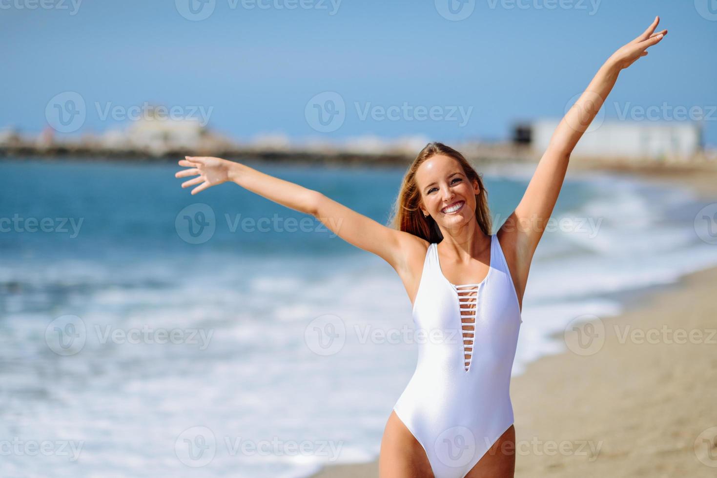 blonde Frau mit schönem Körper im Schwimmer an einem tropischen Strand foto