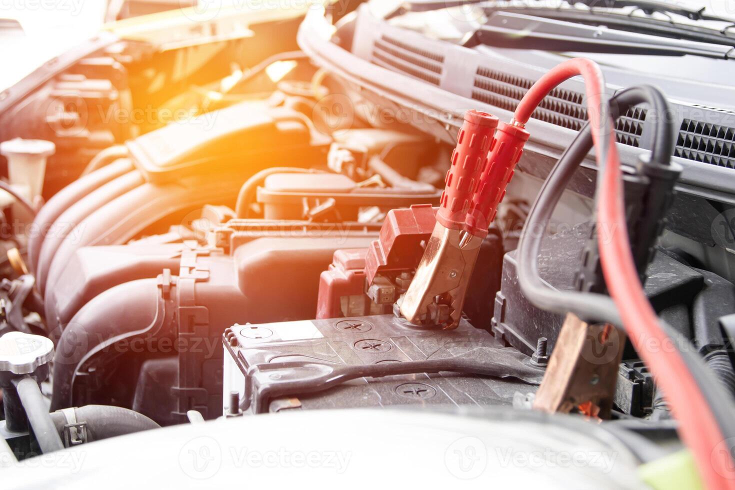 Bedienung Konzept Auto aufladen das Batterie zum Start Motor im Motor Zimmer mit Ladegerät Kabel foto