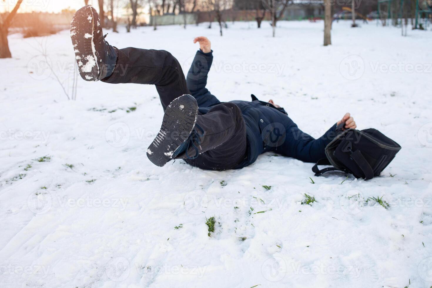 ein Mann Stürze im das Schnee. das Mann rutschte aus und war verletzt. fallen auf Eis. Winter. Fraktur, Prellung, Luxation. foto